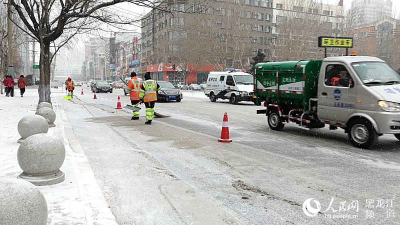 环卫工人、清雪车及时清理各主要街路的积雪。焦洋 摄