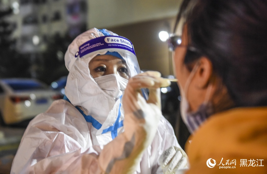 在哈爾濱道外區大有坊街道遼河社區核酸檢測點，工作人員在為居民進行核酸取樣。人民網 張哲鑫攝