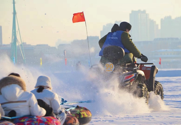 游客在松花江面上体验雪地摩托的速度与激情