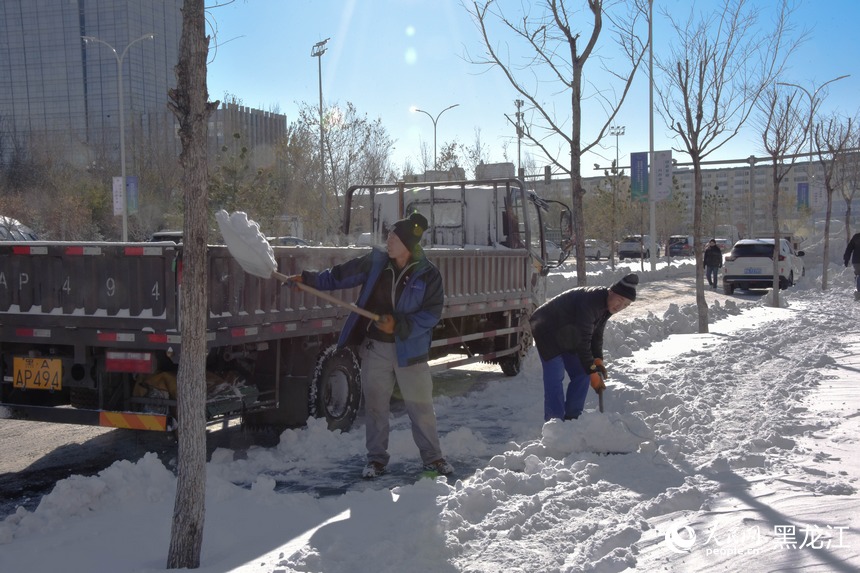 工人正在将雪装车。人民网 徐成龙摄