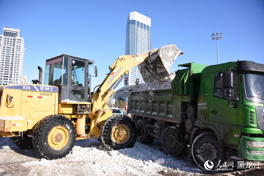 將積雪裝車外運。人民網 徐成龍攝