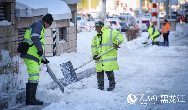 哈尔滨市区内环卫工人正在清雪。人民网记者 苏靖刚摄