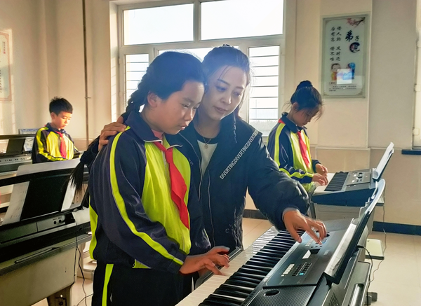 音樂老師正在指導同學們學習電子琴彈奏