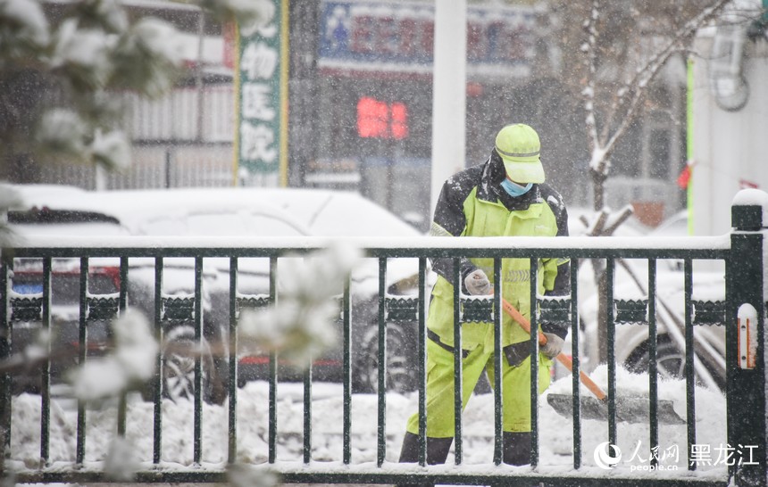 环卫工人正在清理道路积雪。人民网记者 苏靖刚摄