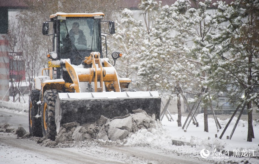 铲车正在清理路边积雪。人民网记者 苏靖刚摄
