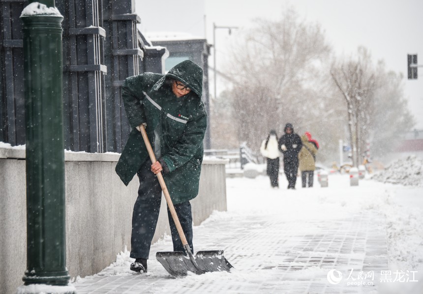 哈尔滨地铁工作人员正在清理地铁站周边积雪。人民网记者 苏靖刚摄