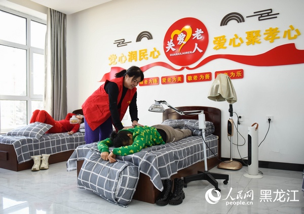 志愿者正在为辖区老人进行肩颈理疗按摩康复。人民网记者 苏靖刚摄