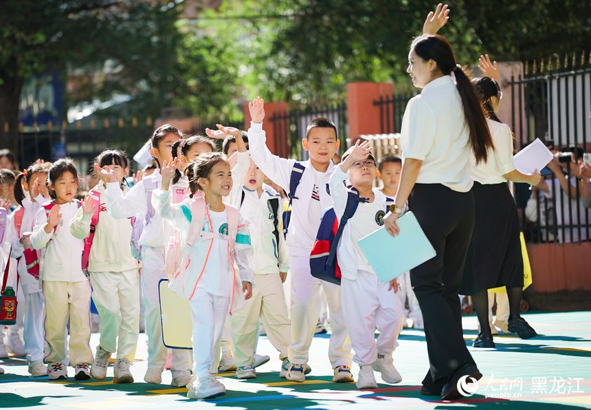 哈爾濱市紅岩小學一年級新生在老師的指引下有序進入校園。人民網記者 蘇靖剛攝