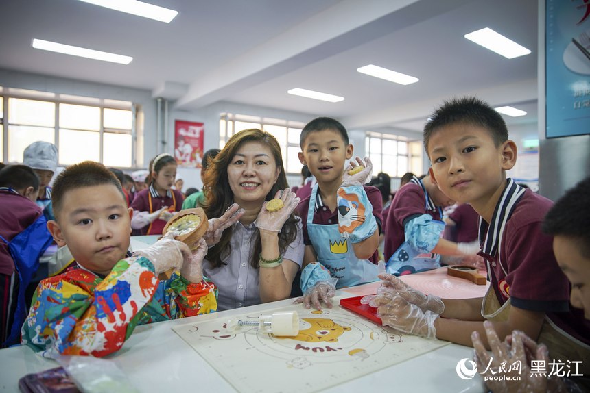 哈爾濱市繼紅小學南崗校區，老師與學生們共同制作中秋月餅。人民網記者 張哲鑫攝