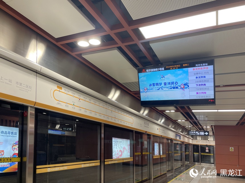 地铁站电子屏滚动播放亚冬会吉祥物“滨滨”“妮妮”及亚冬会宣传视频、海报、标语。人民网 于洋摄