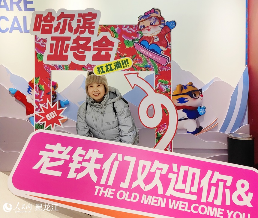 游客在哈尔滨亚冬会拍照打卡点留念。人民网 于洋摄