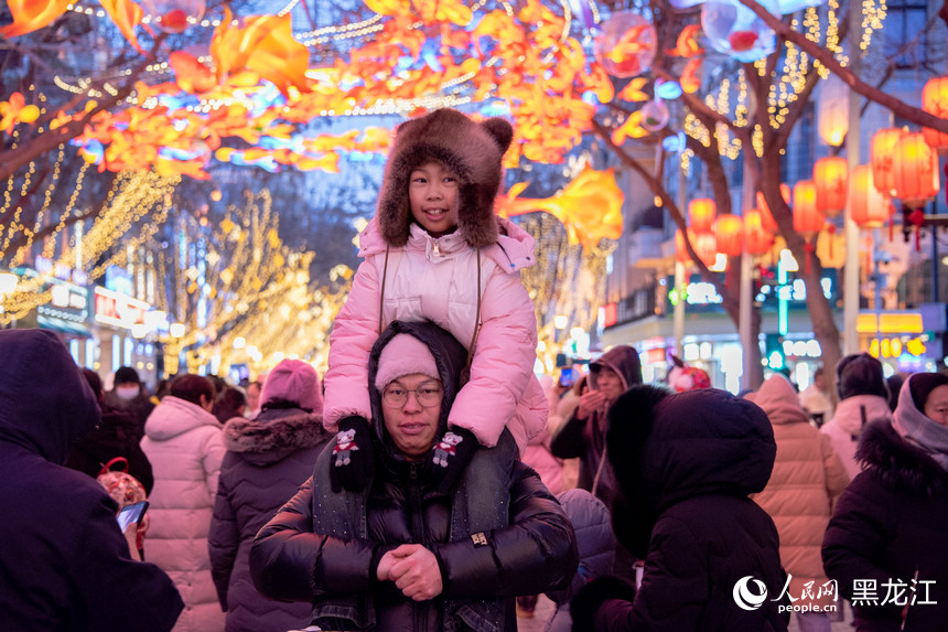 市民游客在中央大街赏花灯。