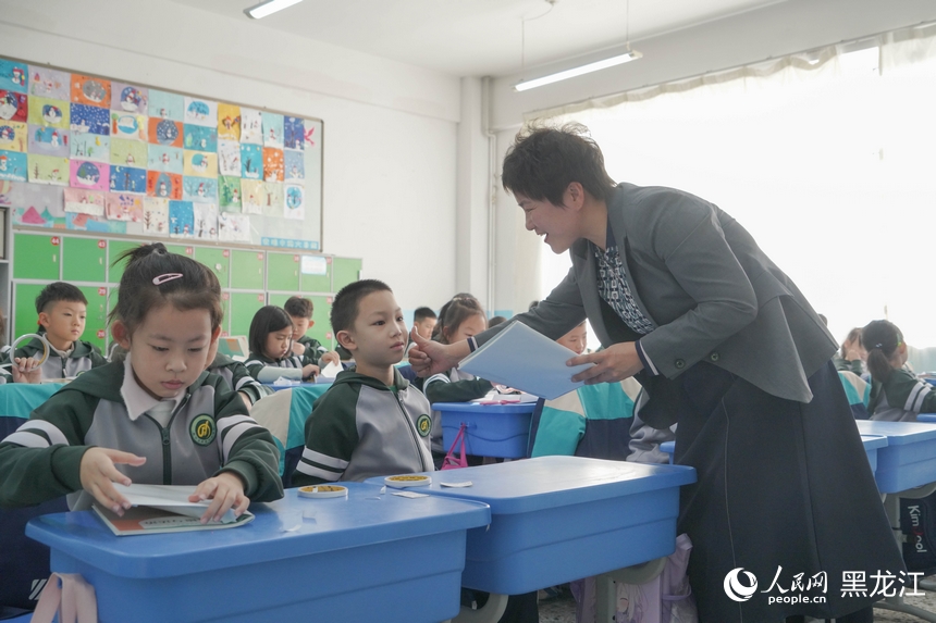 哈尔滨市继红小学校老师在开学第一天的课堂上给学生点赞。人民网 徐成龙摄