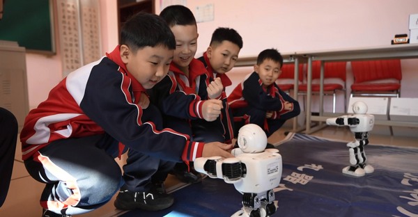 在这堂“开学第一课”上，鸡西虎林市第五小学校的学生与机器人进行互动。虎林市融媒体中心供图