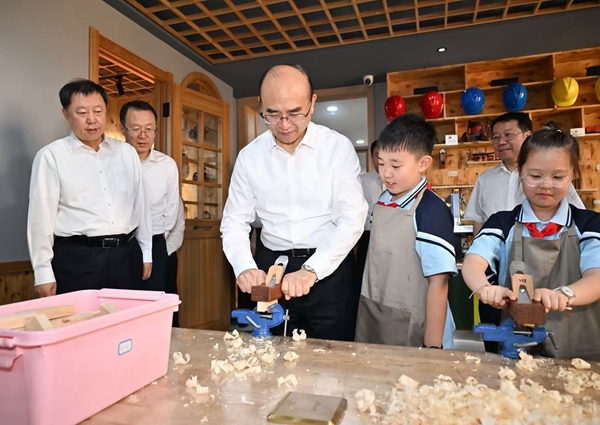 在花园小学校劳动实践课堂上，许勤与孩子们一起动手操作。