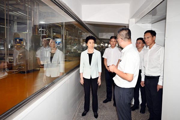 在百家得冷凍食品有限公司，梁惠玲察看企業生產車間，了解企業生產經營情況。