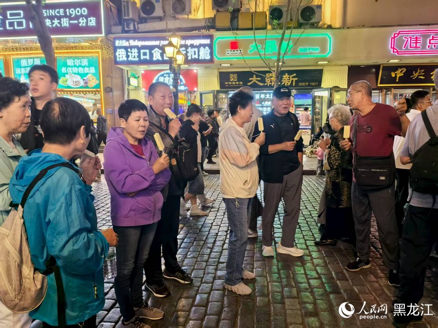 游客在中央大街品尝马迭尔冰棍。