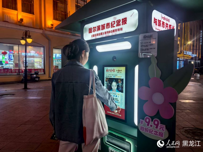 游客在中央大街体验哈尔滨城市纪念报。