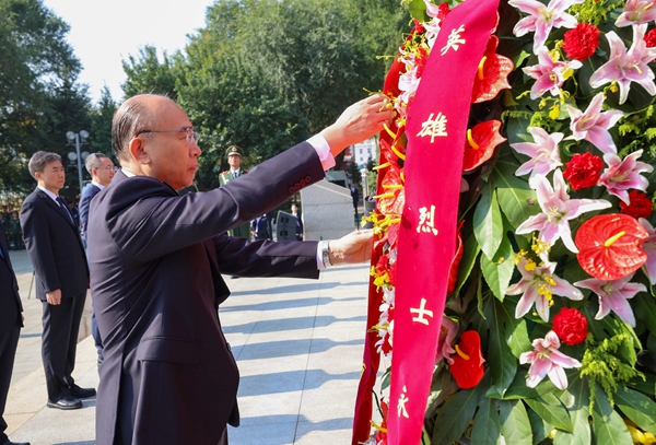 许勤缓步上前，仔细整理花篮缎带。