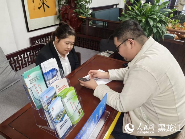 工作人员在售楼处帮助用户办理公积金贷款业务。人民网记者 张齐摄