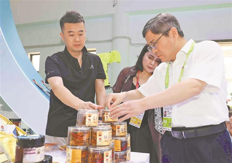 为客商介绍龙江展品。黑龙江日报记者 张澍摄