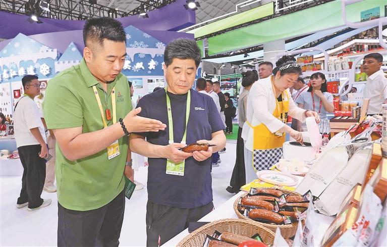 为客商介绍龙江展品。黑龙江日报记者 张澍摄