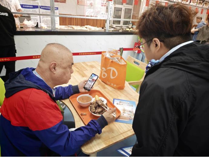中國建設銀行哈爾濱安樂支行工作人員在禾安養老服務中心食堂開展知識宣教。圖片由中國建設銀行黑龍江省分行提供.jpg