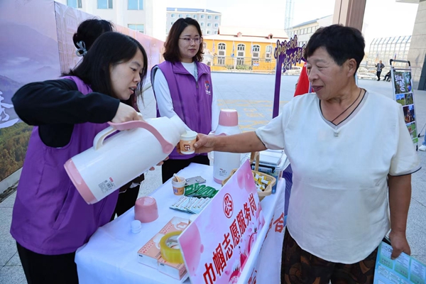 在鐵力高鐵站，巾幗志願者設立服務崗，為來往旅客提供熱飲等。