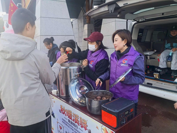 在溪水公園，巾幗志願者設立服務台，為游客免費發放茶葉蛋、玉米等。
