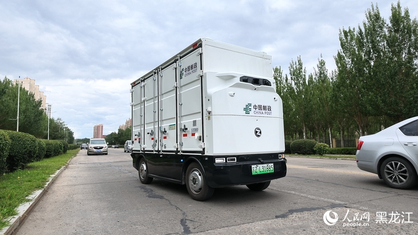 行驶在路面上的无人配送车。人民网记者 徐成龙摄