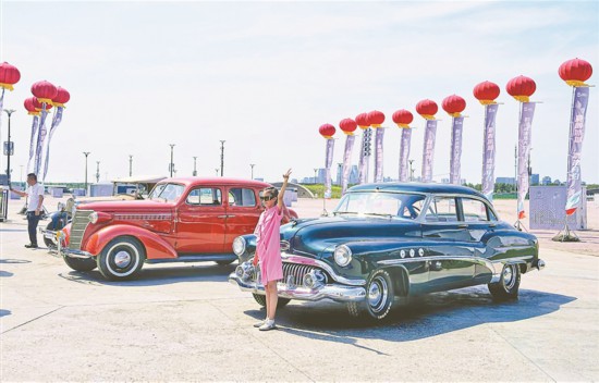 游客与经典汽车合影。
